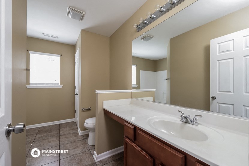 a bathroom with a large mirror and a sink and a toilet