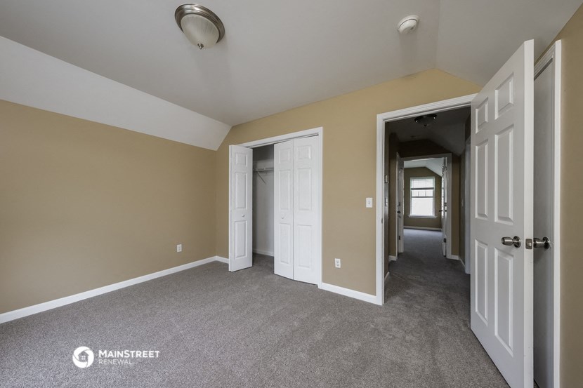 the living room and hallway of an empty house