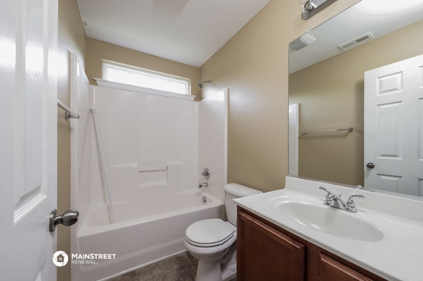 a bathroom with a shower toilet and sink and a mirror