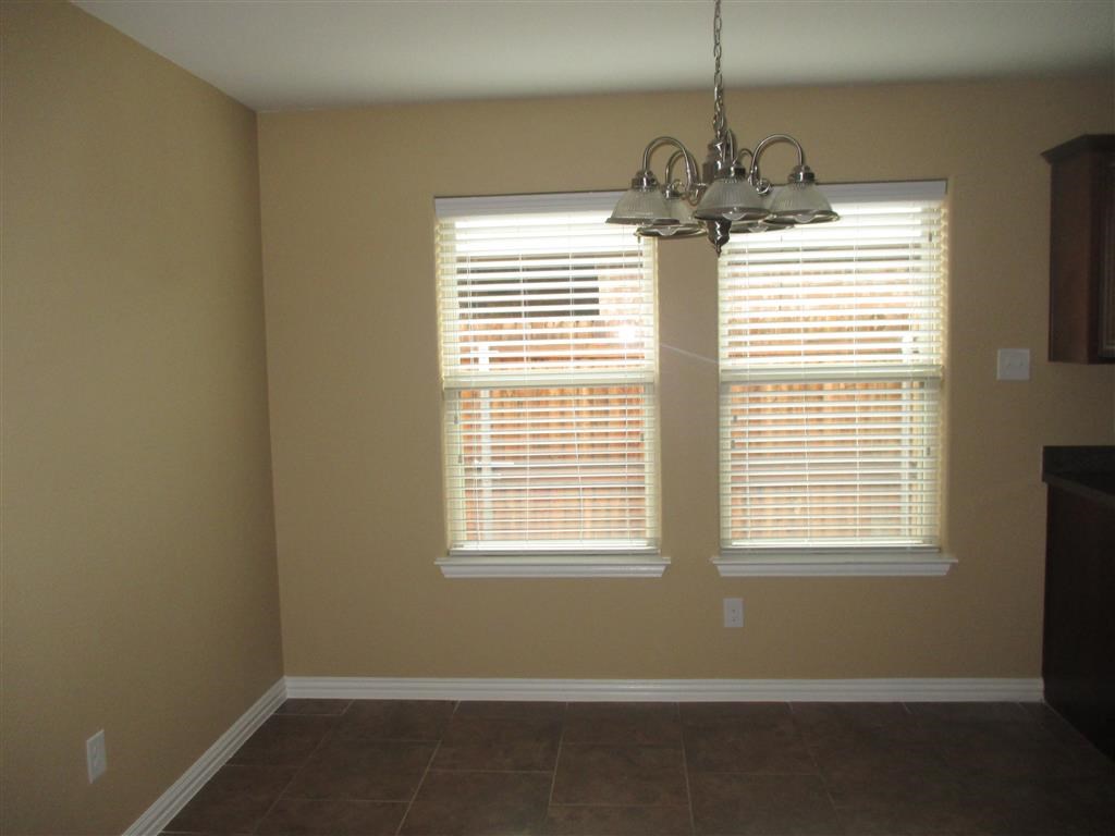 a dining room with two windows and a chandelier