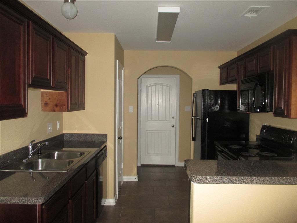a kitchen with a sink and a refrigerator and a door