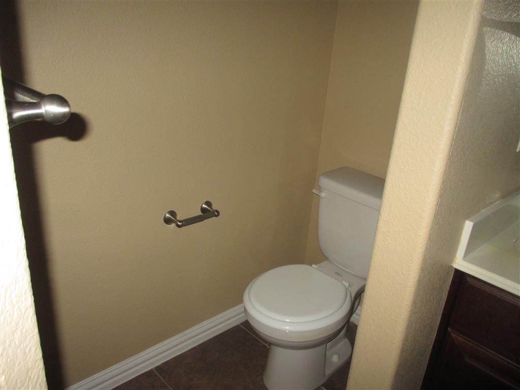 a bathroom with a toilet and a roll of toilet paper
