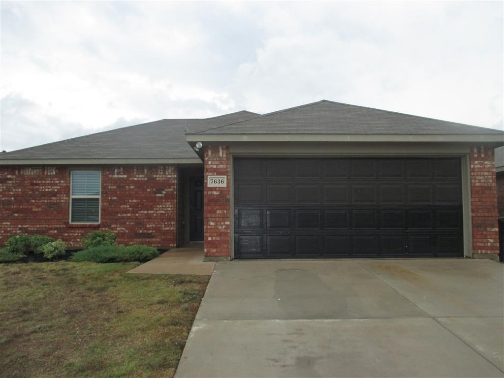 the front of a brick house with a garage door