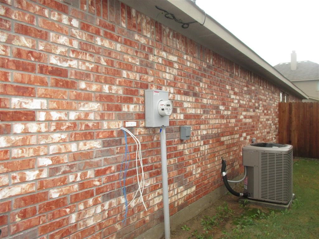 an air conditioner on the side of a brick wall