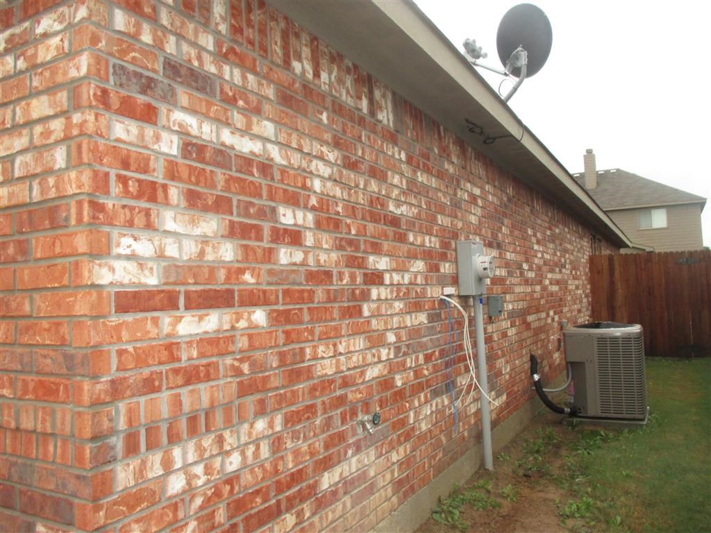the side of a brick wall with an air conditioner