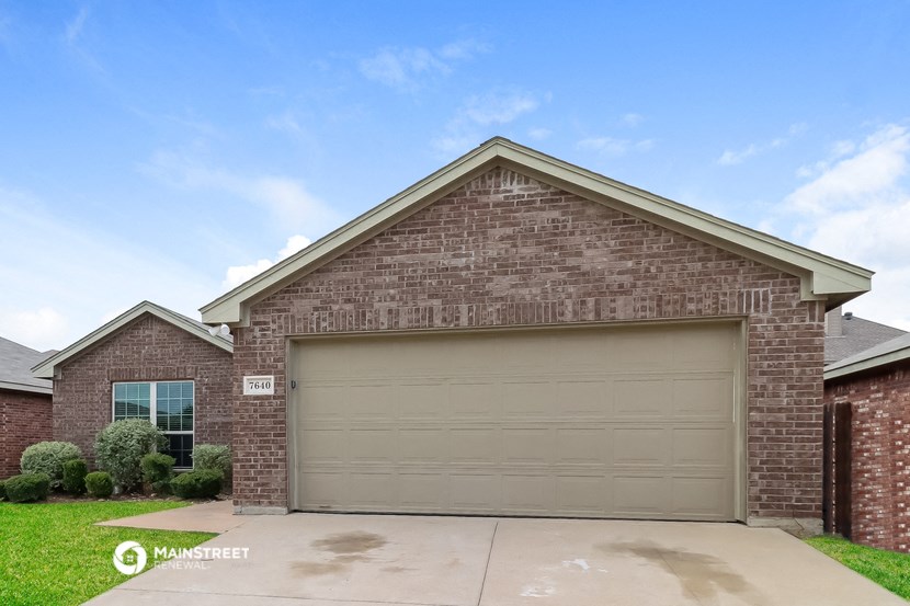 a garage door on the side of a brick house