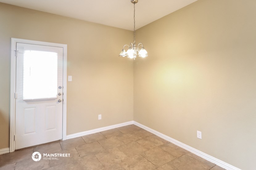 a empty room with a door and a chandelier