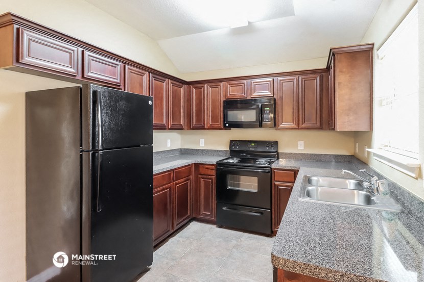a kitchen with black appliances and granite counter tops