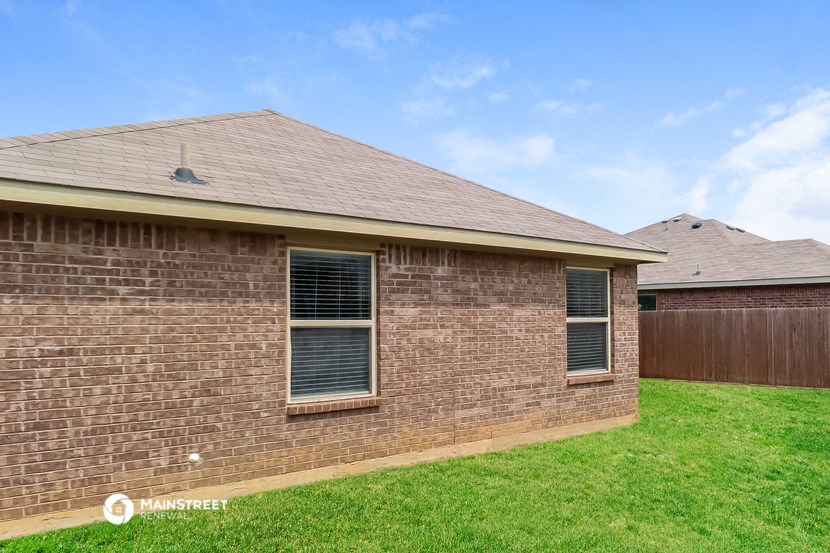a brick house with a yard and a wooden fence