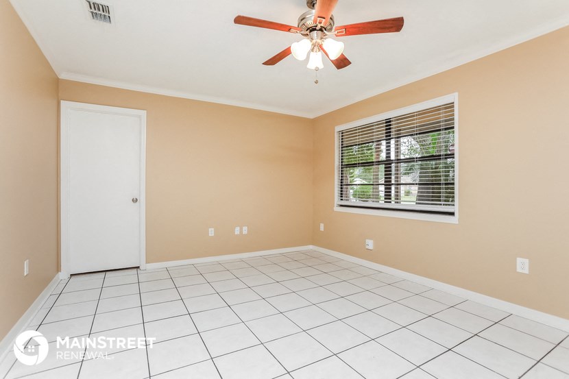 the living room has a ceiling fan and a tile floor