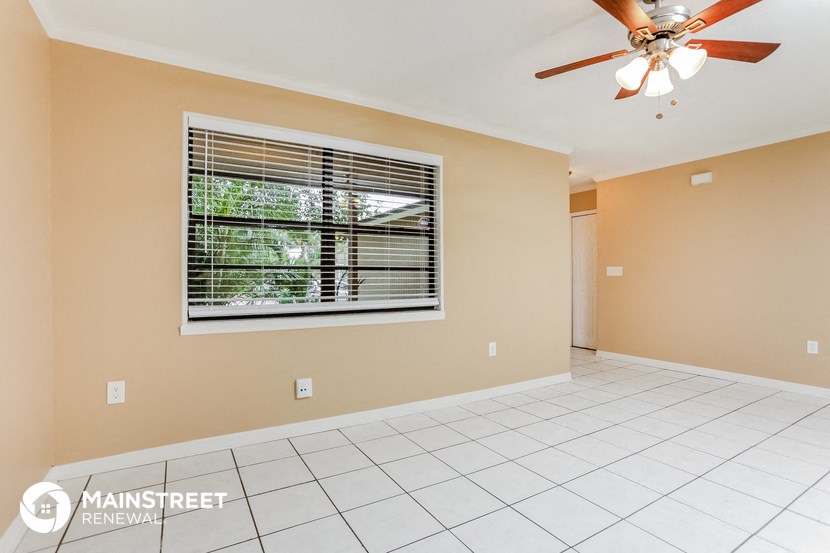 the living room is spacious with a large window and a ceiling fan