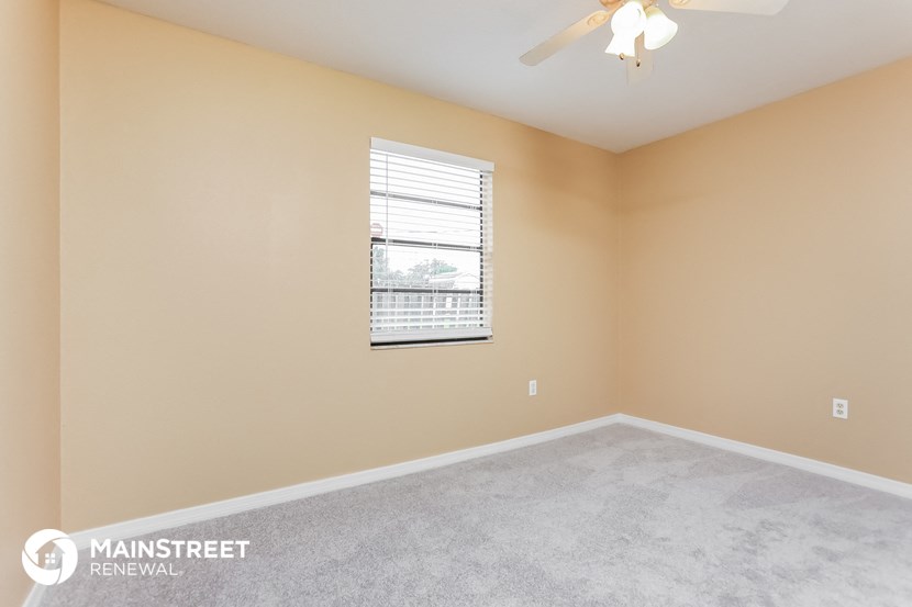 the upstairs bedroom has a ceiling fan and a window