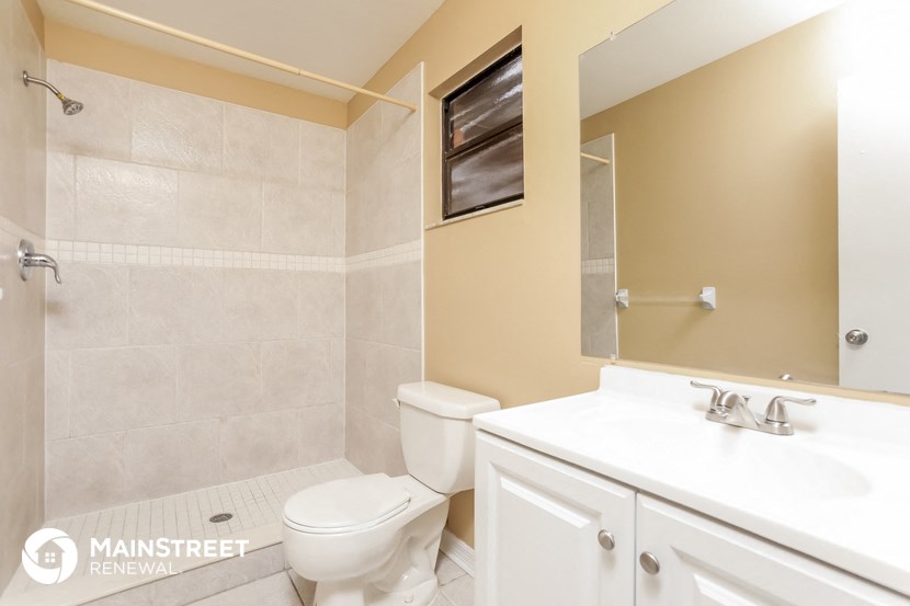 a bathroom with a toilet and a sink and a mirror