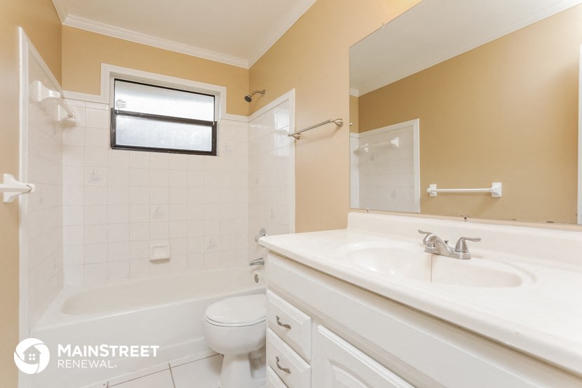 a white bathroom with a sink and a toilet and a tub