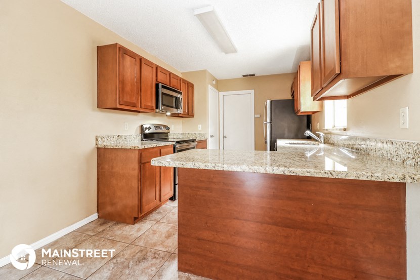 a kitchen with wood cabinets and granite counter tops and a sink