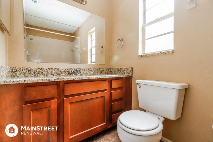 a bathroom with a toilet and a sink and a mirror