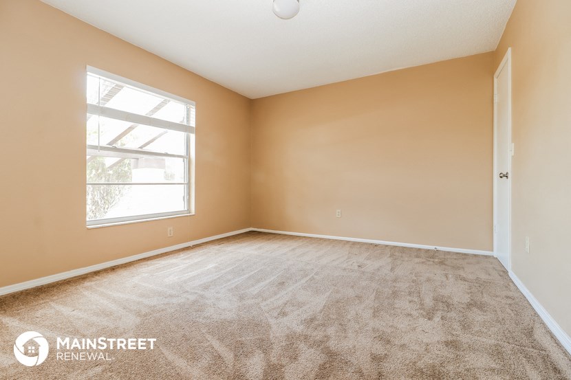 the living room of a home with carpet and a window