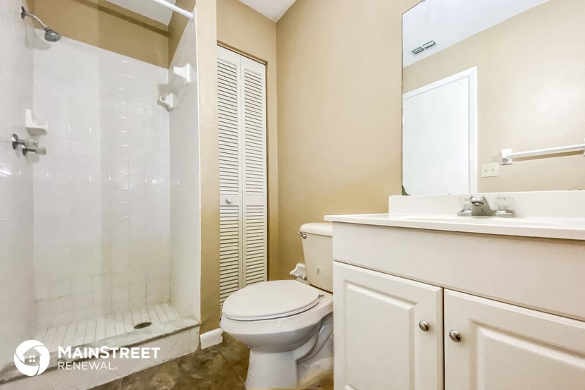 a white bathroom with a shower toilet and sink