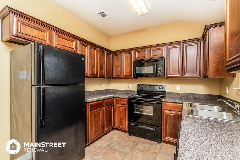a kitchen with black appliances and wood cabinets