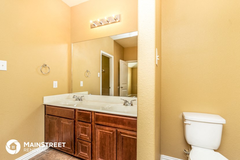 the master bathroom has a large mirror and two sinks