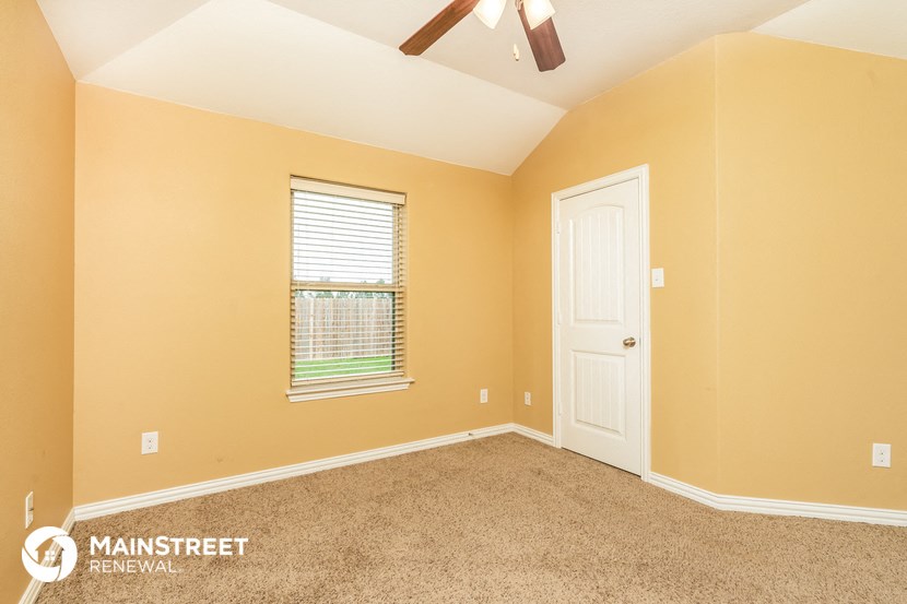 the master bedroom is spacious and has a ceiling fan and a window