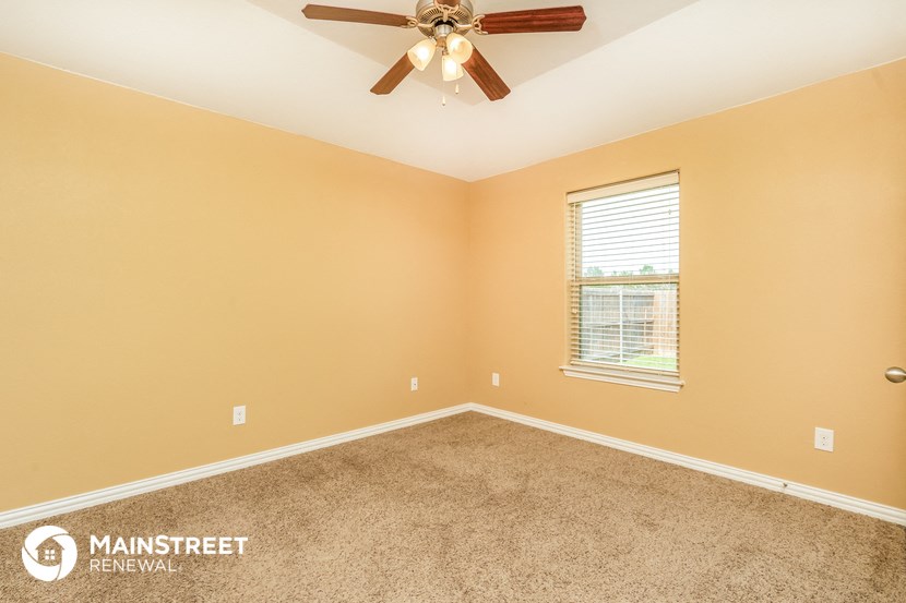 the master bedroom has a ceiling fan and a carpeted floor