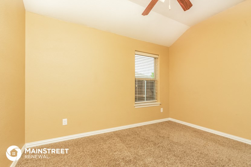 the spacious living room with carpeting and a ceiling fan