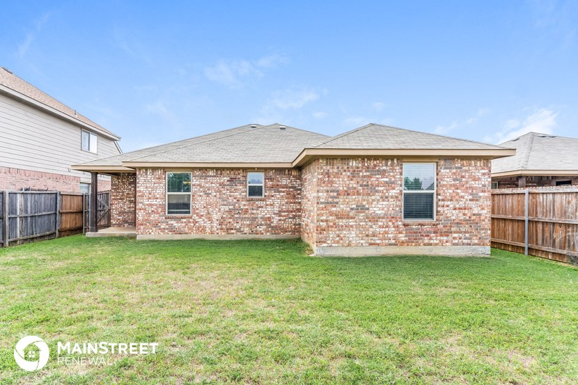 a brick house with a backyard and a wooden fence