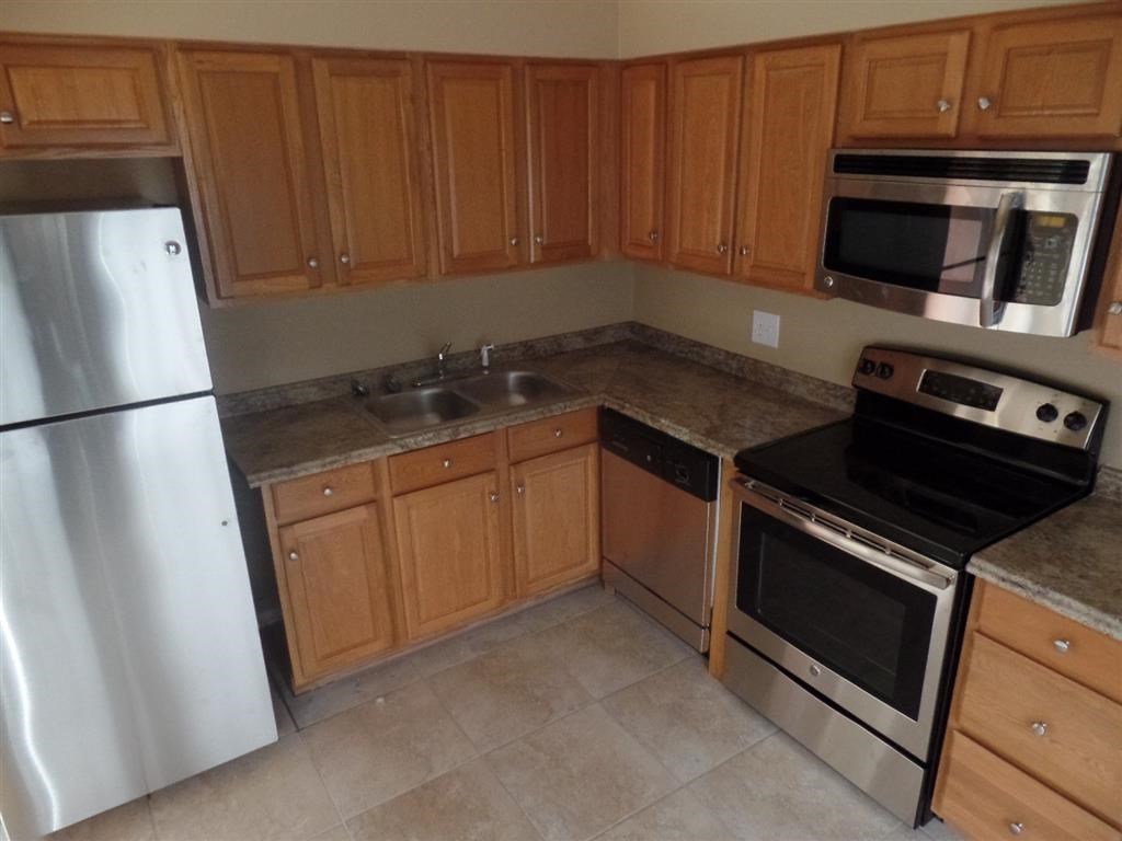 a kitchen with stainless steel appliances and wooden cabinets