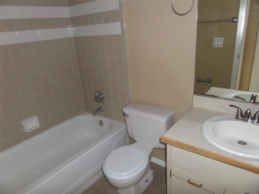 a bathroom with a toilet and a tub and a sink