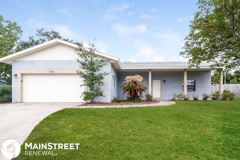 a white house with a lawn and a white garage door