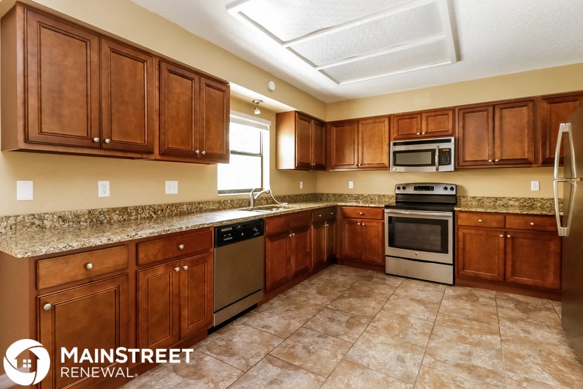 a kitchen with wooden cabinets and stainless steel appliances