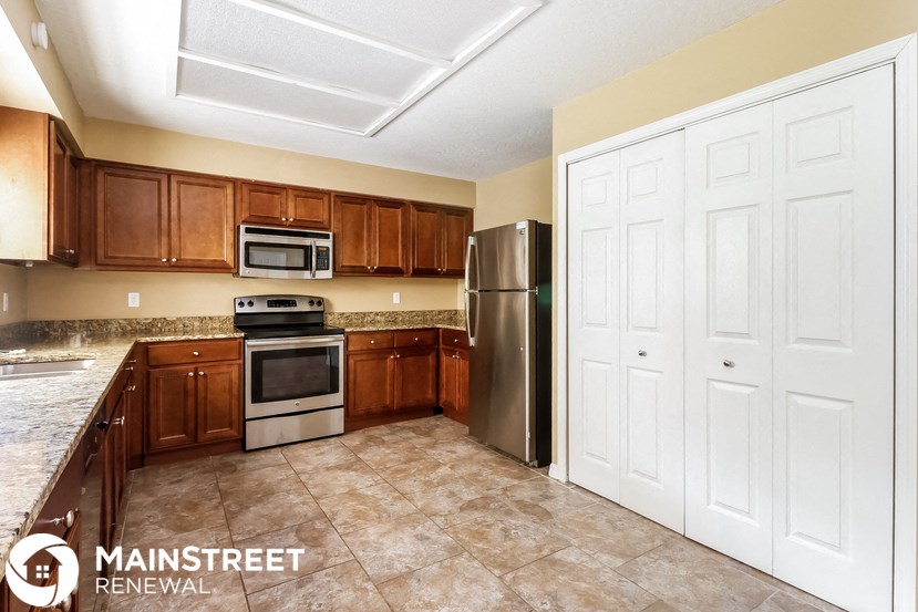 a kitchen with wooden cabinets and stainless steel appliances
