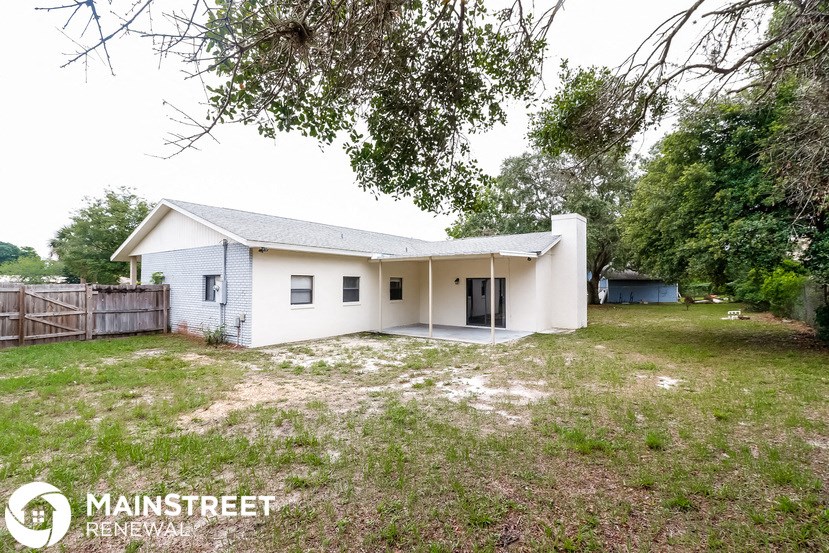 a small white house with a yard and a fence