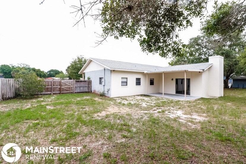 a small white house with a yard and a fence
