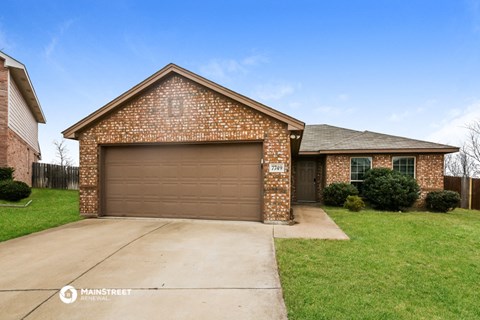 a brown garage door in front of a brick house