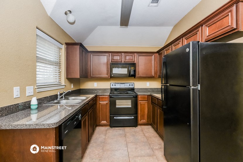 a kitchen with black appliances and wooden cabinets