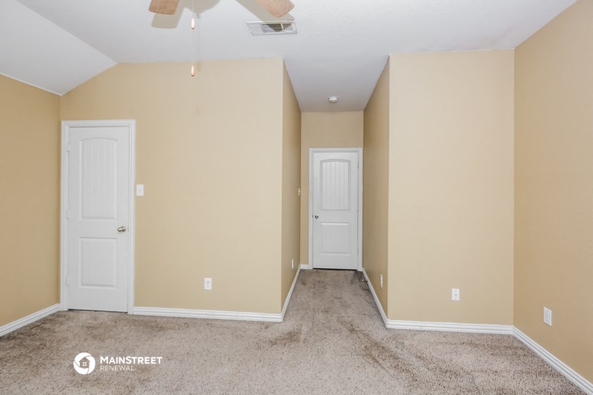 a empty room with two doors and a carpeted floor