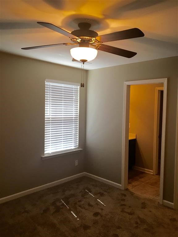 a empty room with a ceiling fan and a window