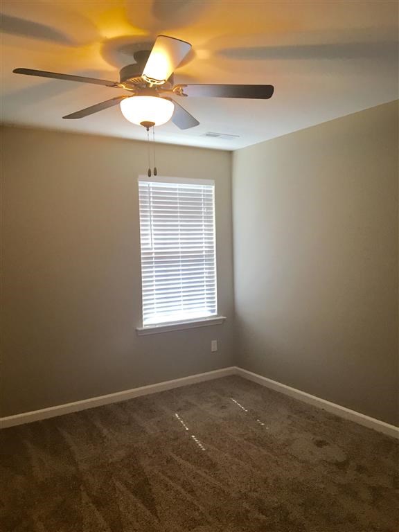 a bedroom with a ceiling fan and a window