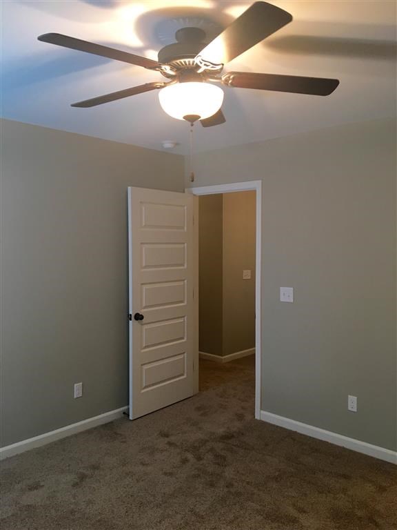 a bedroom with a ceiling fan and a closet