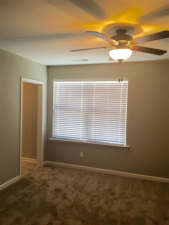a living room with a ceiling fan and a window
