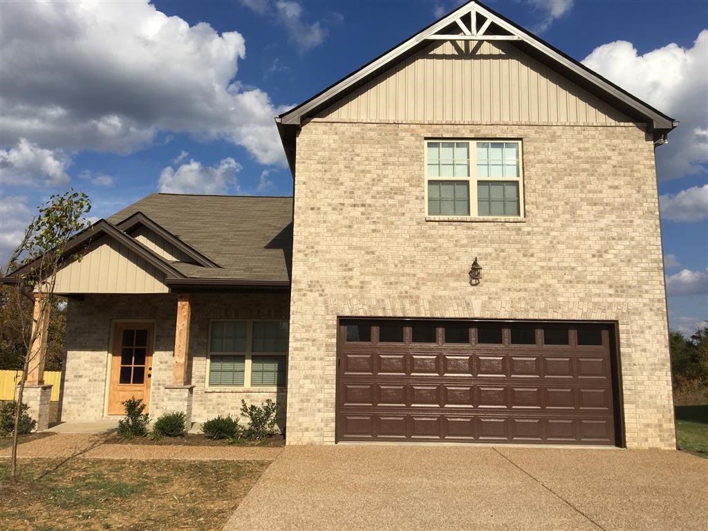 a brick house with a brown garage door