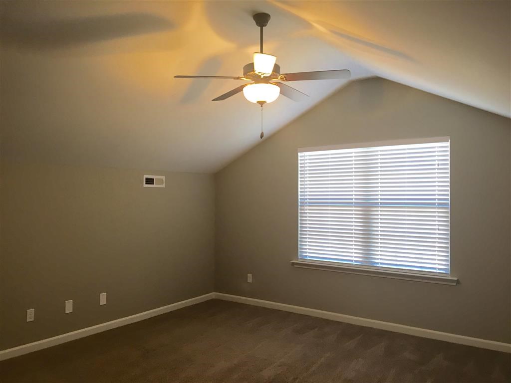 a bedroom with a ceiling fan and a window