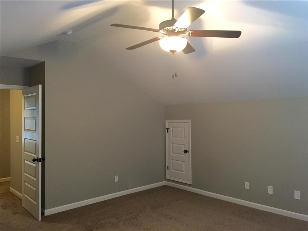 a bedroom with a ceiling fan and a door