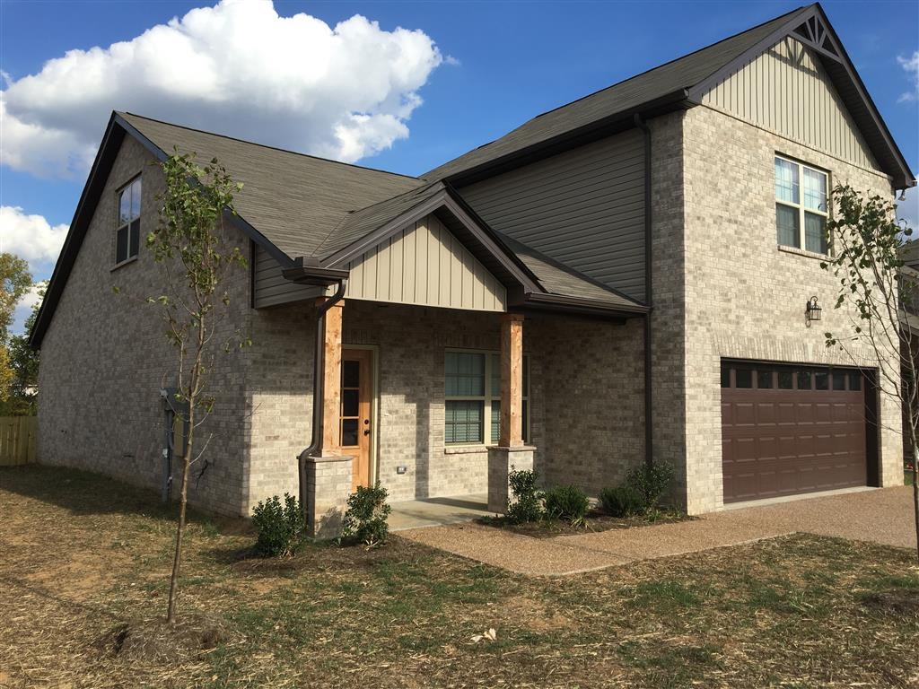 a house with a stone exterior and a brown garage door