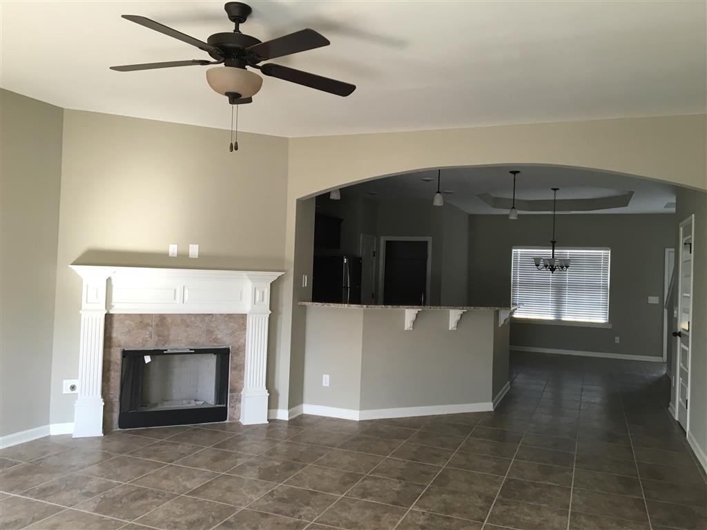 a living room with a fireplace and a ceiling fan