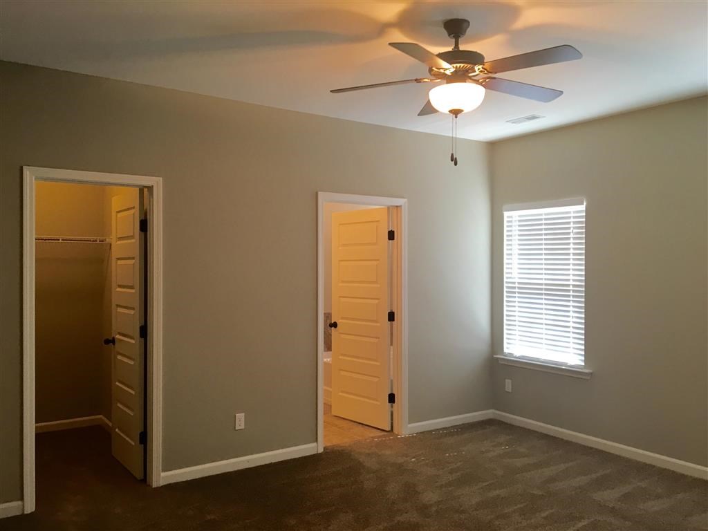 a empty room with a ceiling fan and an open door