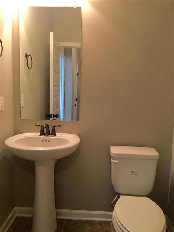 a bathroom with a sink toilet and a mirror