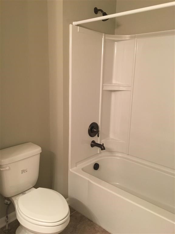 a white bathroom with a toilet and a tub
